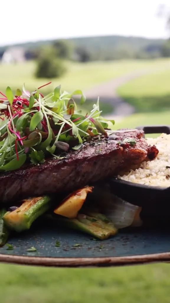 A plate of steak, vegetables, and cheese grits.