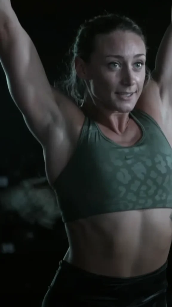 Muscular woman in green sports bra exercising.